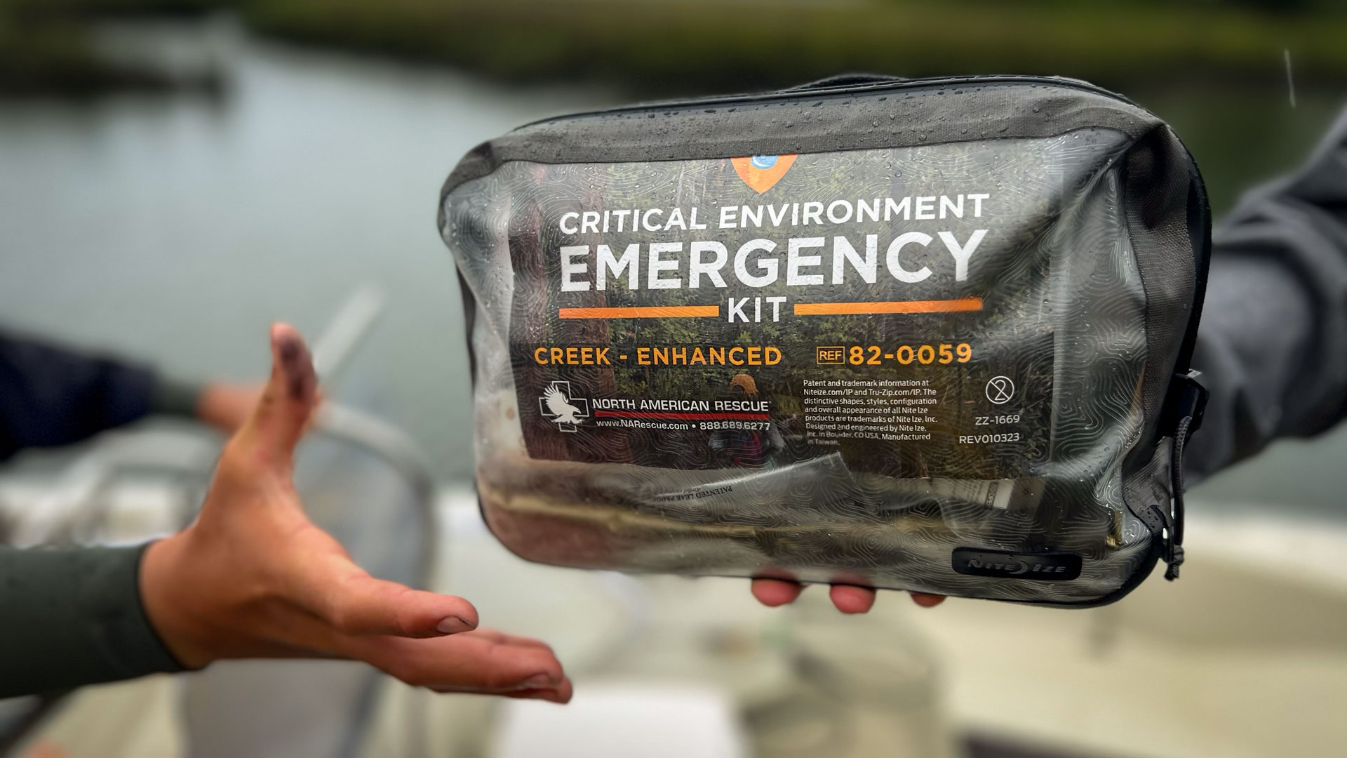 Critical Environment Emergency Kit Being Handed To Person On Boat